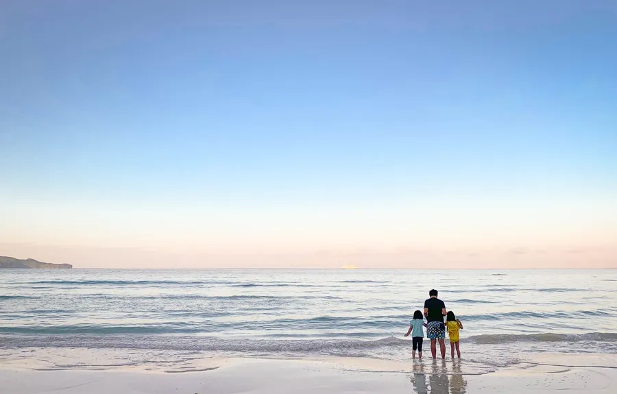A family enjoying an Okinawa beach at sunset