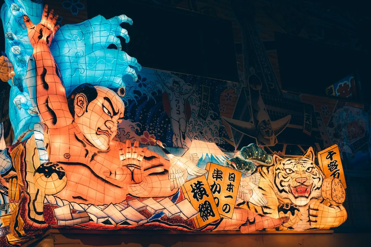 A giant illuminated warrior-and-tiger Nebuta float glowing in the night