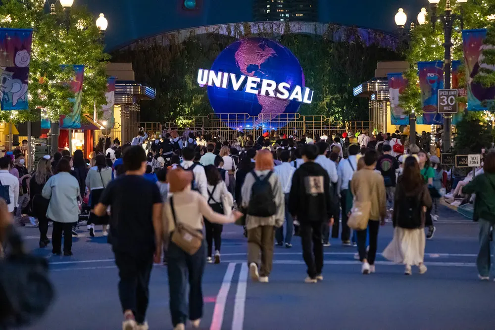 Foule du soir se dirigeant vers le globe Universal à l'entrée d'Universal Studios Japan